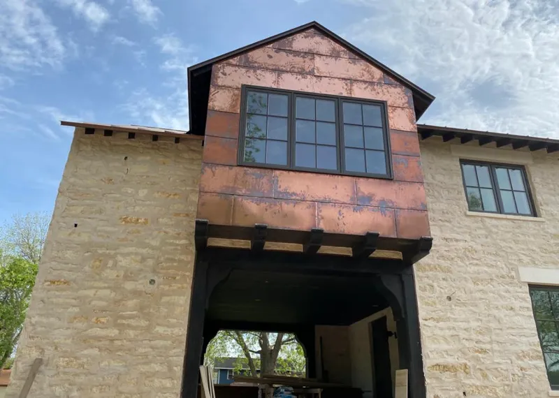 Copper metal panel facade on a stone building for Roof Repair in North Alamo